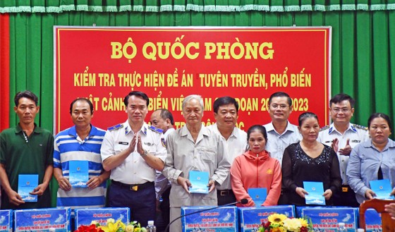 Thiếu tướng Vũ Trung Kiên (thứ 3 từ trái sang) tặng quà đến bà con ngư dân thị trấn Sông Đốc