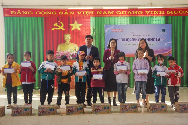 Lãnh đạo địa phương và đại diện nhà tài trợ tặng quà các em học sinh vượt khó, học tốt