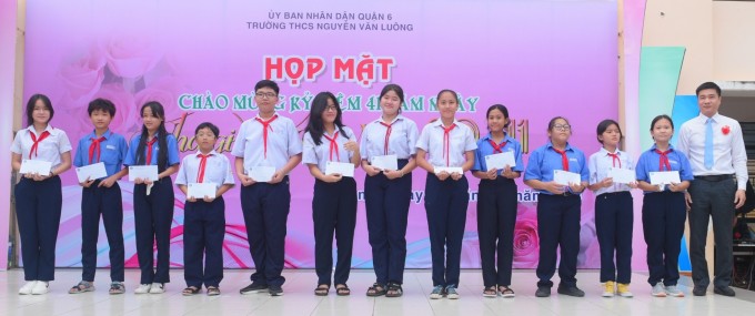 Học sinh có hoàn cảnh khó khăn của trường THCS Nguyễn Văn Luông được trao học bổng. Ảnh: BHXH TP HCM