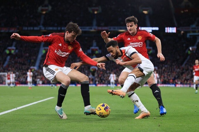 Maguire (áo đỏ, bên phải) cùng Lindelof phòng ngự trong trận Man Utd thắng Luton Town 1-0 ở vòng 12 Ngoại hạng Anh tối 11/11, trên sân Old Trafford. Ảnh: Offside