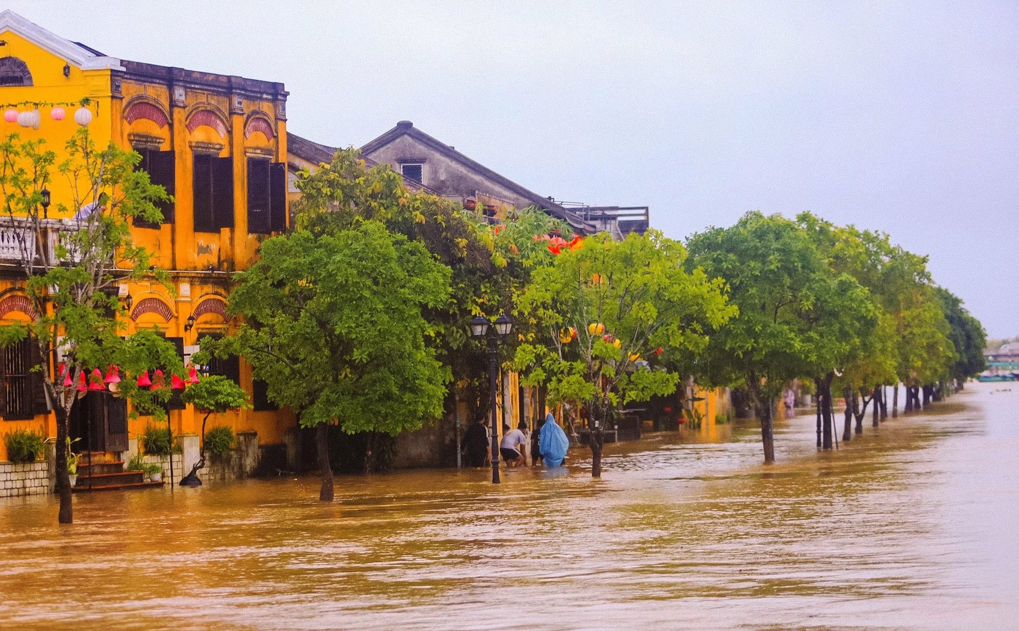 Tranh thủ lũ rút, người dân Hội An tất bật dọn bùn non để đón du khách - Ảnh 1.