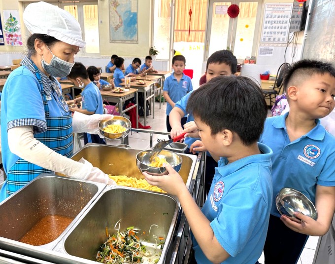 Học sinh lớp 2.3 trường Tiểu học Đinh Tiên Hoàng lấy đồ ăn trưa, ngày 11/10. Ảnh: Lệ Nguyễn