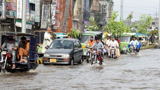 Người dân di chuyển trên đường ngập nước tại TP Lahore, Pakistan, ngày 5-7-2023. Ảnh: Tân Hoa xã