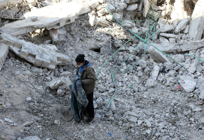 Người đàn ông đứng trên đống đổ nát từng là ngôi nhà của ông ở Jableh, Syria, ngày 12/2. Ảnh: Reuters