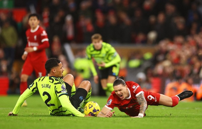 Tiền đạo Liverpool Nunez (số 9) ngã sau một pha tranh chấp với trung vệ Arsenal Saliba trong trận hòa 1-1 trên sân Anfield ở vòng 18 Ngoại hạng Anh ngày 23/12. Ảnh: Reuters