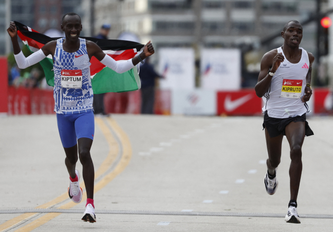 Kelvin Kiptum (trái) chạy mừng chiến thắng ở Chicago Marathon 2023 ngày 8/10, trong khi đồng hương Rhonex Kipruto về đích. Ảnh: Reuters