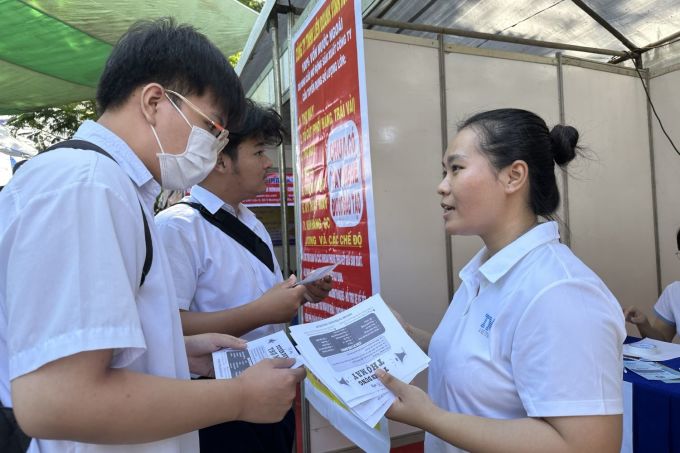 Nhân viên tuyển dụng của Công ty TNHH Liên doanh Vĩnh Hưng tư vấn cho người tìm việc, sáng 17/12. Ảnh: Lê Tuyết