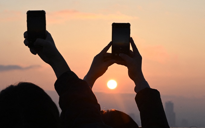 People take pictures as they observe the last sunset of the year on a viewing deck at Namsan tower in Seoul (AFP-Getty).jpg