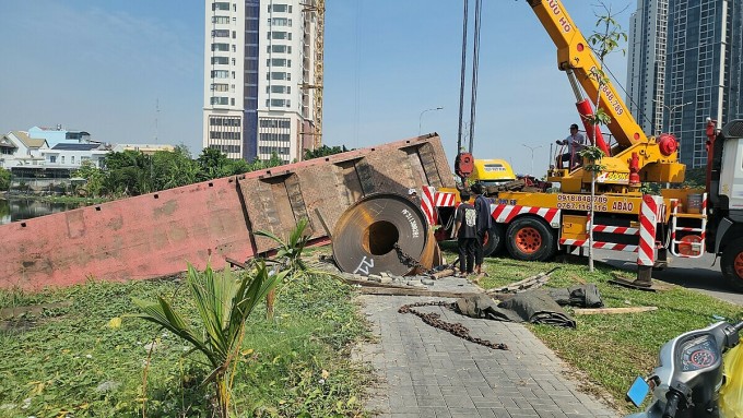 Lực lượng chức năng điều xe cẩu di dời cuộn thép và xe gặp nạn. Ảnh: Đình Văn