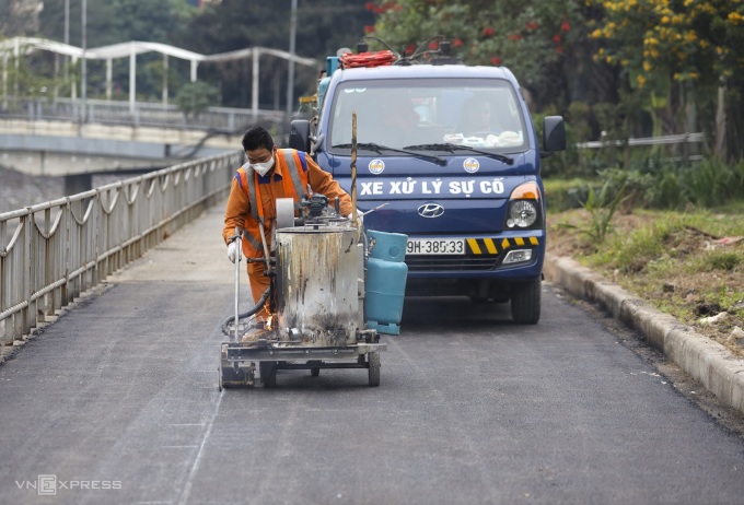 Công nhân sơn kẻ lại vạch đường, chiều 26/1. Ảnh: Việt An