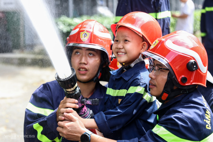 Bé Trung Quân, 7 tuổi, TP HCM, bị ung thư máu, được trải nghiệm làm lính cứu hoả như mơ ước khi đang điều trị tại Bệnh viện Nhi đồng 2. Ảnh: Quỳnh Trần.