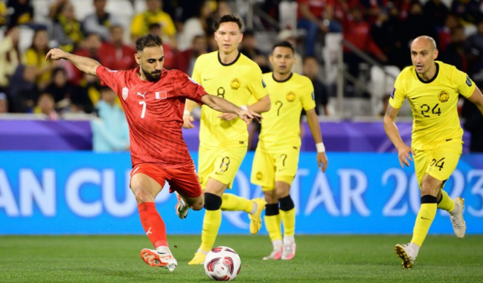 Ali Madan đi bóng và dứt điểm trong vòng vây các cầu thủ Malaysia, trên sân Jassim Bin Hamad, Qatar hôm 20/1. Ảnh: AFC