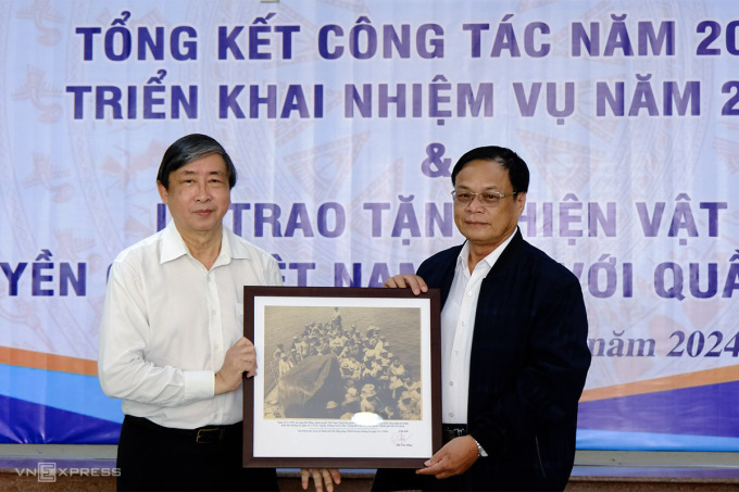 Ông Bùi Văn Tiếng, Chủ tịch Hội khoa học lịch sử TP Đà Nẵng (bên phải) tặng ảnh bằng chứng về Hoàng Sa của Việt Nam cho ông Võ Ngọc Đồng, Chủ tịch UBND huyện Hoàng Sa. Ảnh: Nguyễn Đông