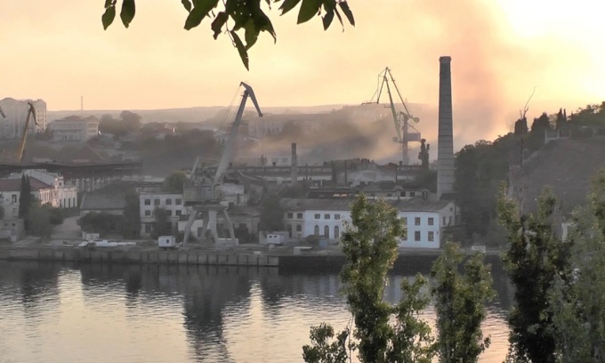 Khói bốc lên từ xưởng đóng tàu bị trúng tên lửa ở Sevastopol, Crimea, tháng 9 năm ngoái. Ảnh: Reuters