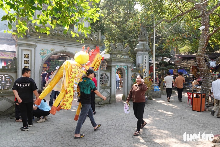 Theo quan sát, vào sáng 21-2, lượng du khách đến đền chủ yếu là người dân từ các tỉnh phía Bắc. Người dân mua sắm lễ vật, trong đó có ngựa giấy để vào đền làm lễ - Ảnh: LÊ MINH