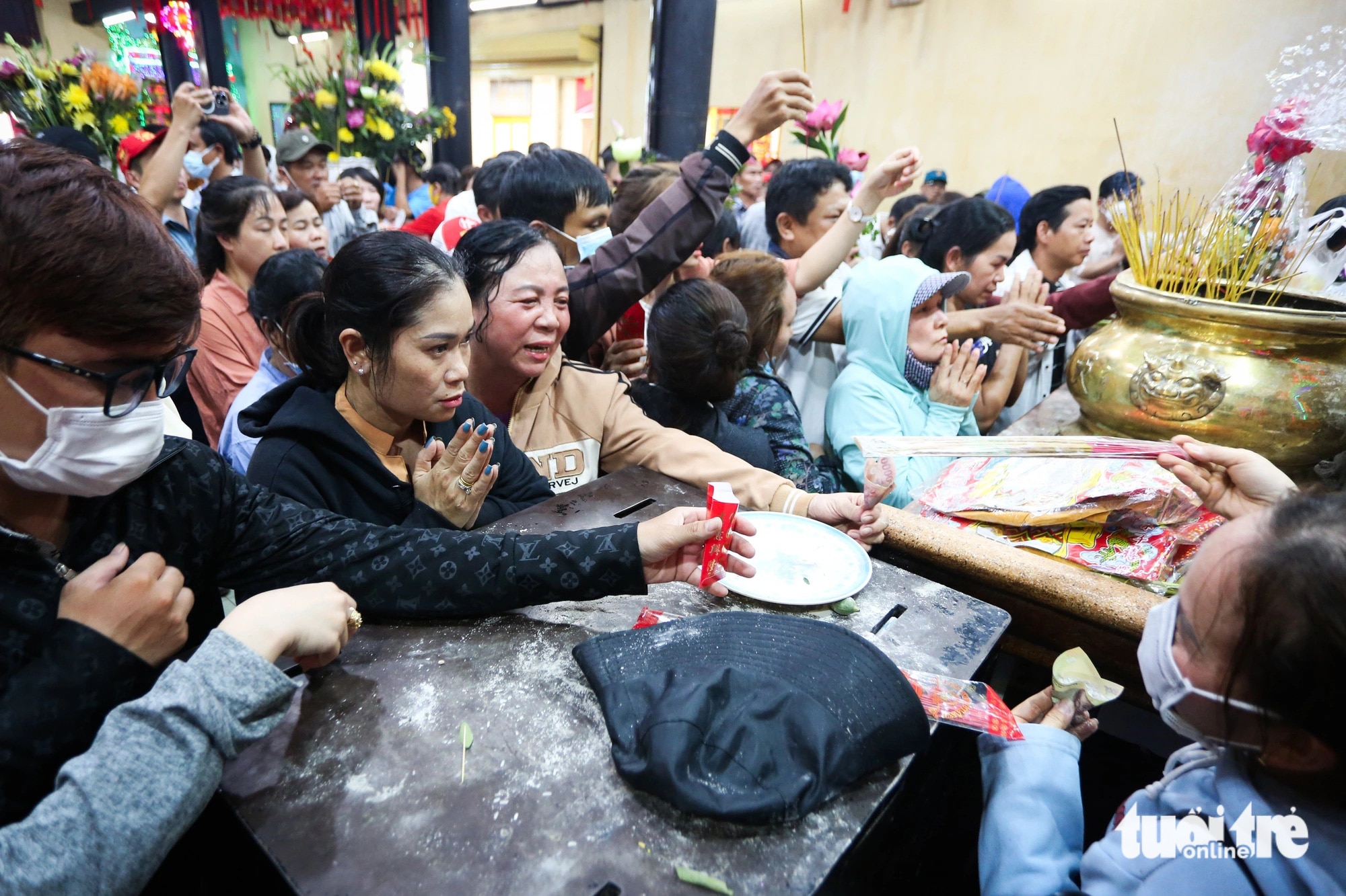 Người dân mang theo bao lộc lấy tro từ các lư hương mang về để cầu may mắn cho gia đình - Ảnh: PHƯƠNG QUYÊN 