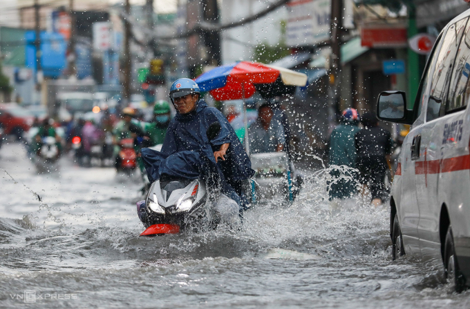 Người đi xe máy chới với trong dòng nước ngập đường Tô Ngọc Vân - một trong điểm ngập ở TP Thủ Đức. Ảnh: Quỳnh Trần