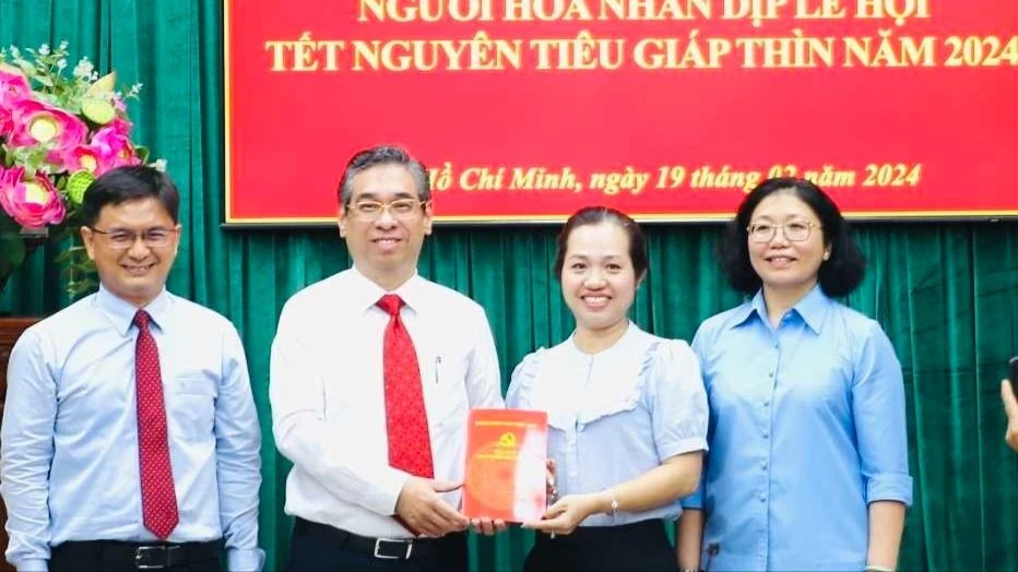 Phó Bí thư Thành ủy TPHCM Nguyễn Phước Lộc trao tặng tiền lì xì cho Quỹ an sinh, khuyến học quận 5. Ảnh: VIỆT DŨNG