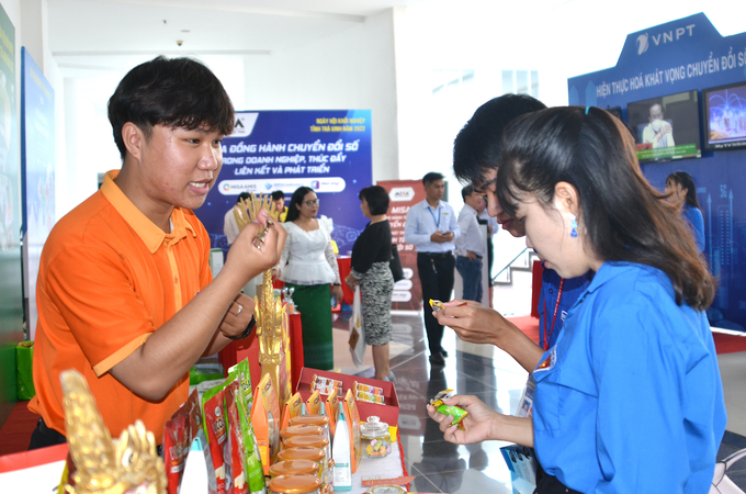 Các bạn trẻ tham quan gian hàng của Vicosap, thích thú với sản phẩm kẹo dừa và sữa chua dừa sáp. Ảnh: Minh Đảm.