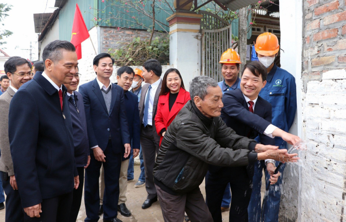 Người dân và chính quyền xã Minh Châu, huyện Ba Vì vui mừng đón những dòng nước sạch đầu tiên lắp đến các hộ gia đình hôm 7/2. Ảnh: Hoàng Phong