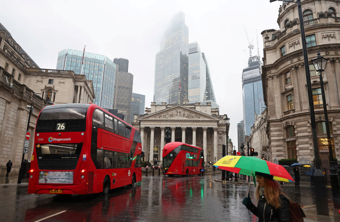 Xe bus và người đi bộ trên một con phố ở London (Anh) hôm 8/2. Ảnh: Reuters