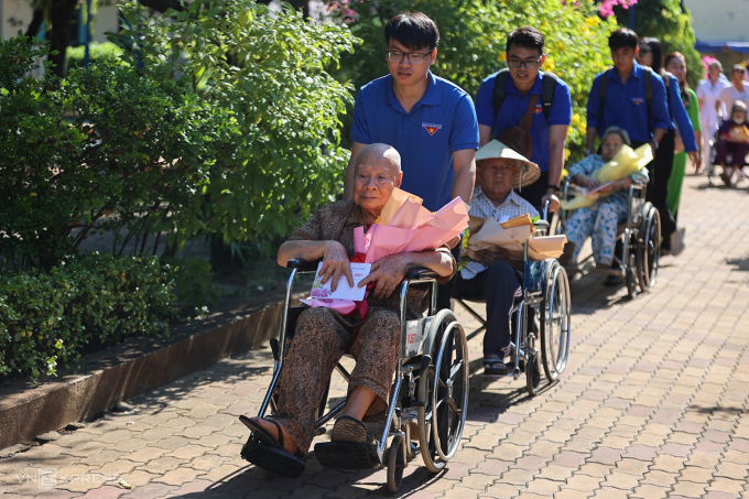 Nghệ sĩ Lam Sơn (hàng đầu), Mạc Can (hàng thứ hai) được tình nguyện viên hỗ trợ di chuyển trong buổi tiếp nhận các tên tuổi gạo cội vào sống ở Trung tâm dưỡng lão Thị Nghè. Ảnh: Quỳnh Trần