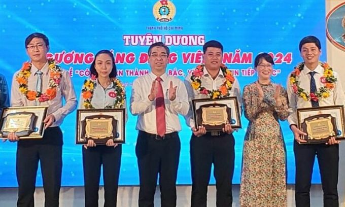 Ông Nguyễn Phước Lộc, Phó Bí thư Thành ủy TP HCM và bà Trần Thị Diệu Thúy, Chủ tịch Liên đoàn lao động TP HCM chúc mừng các đảng viên tiêu biểu, sáng 3/2. Ảnh: An Phương