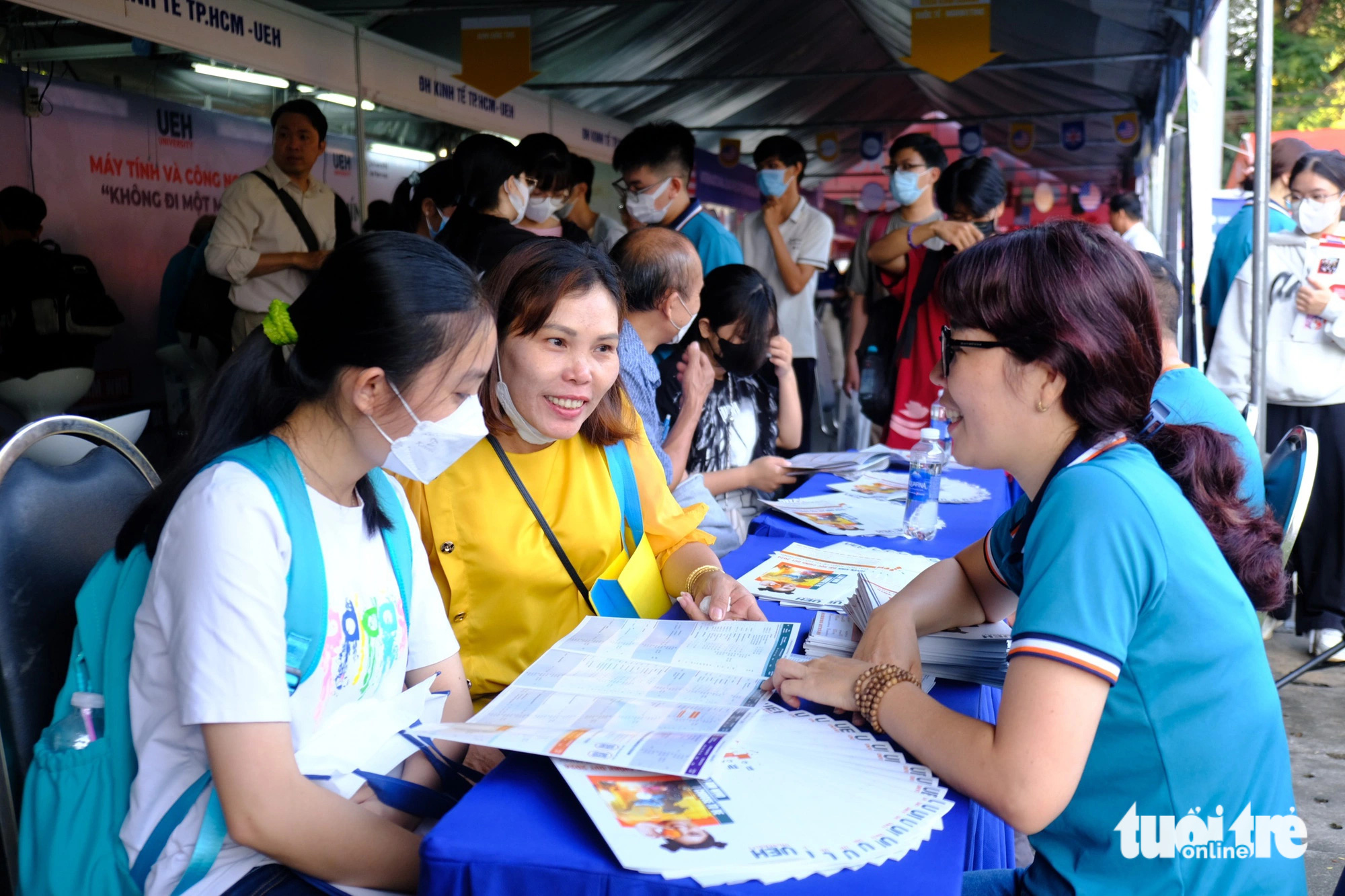 Phụ huynh Kim Phượng (huyện Củ Chi) cho biết chị biết đến ngày hội nên dẫn con gái đến tìm hiểu, tâm trạng của chị và con đến đây rất nôn nao và vui, cứ như dẫn con đi thi vậy. Bé ít nói nên đi cùng con cho an tâm, hiện con muốn tham khảo khối ngành sư phạm và thú y - Ảnh: NGỌC PHƯỢNG