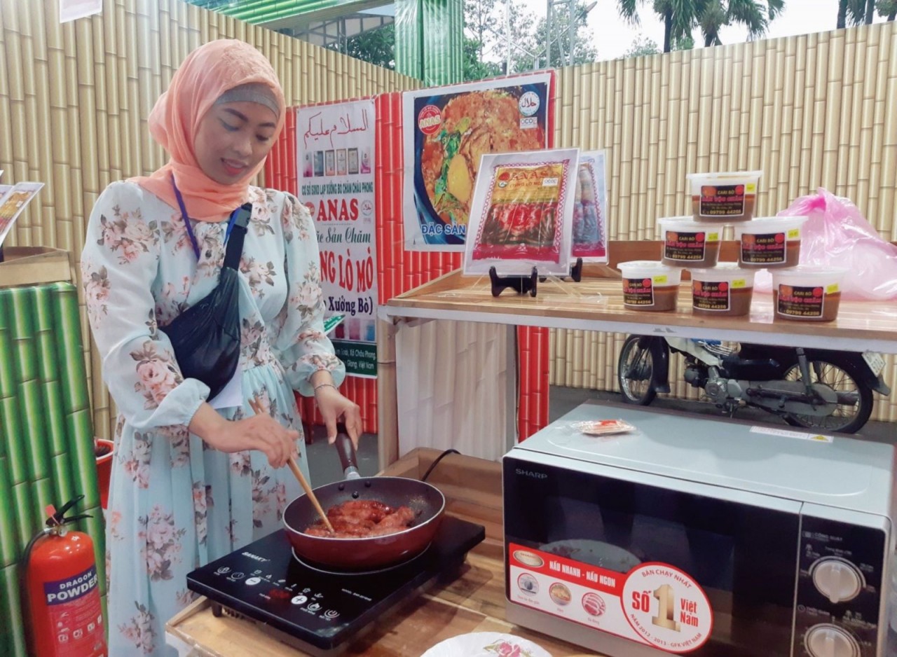 Cô gái Chăm Hứa Thị Rokya ở ấp Phũm Xoài, xã Châu Phong (TX. Tân Châu, tỉnh An Giang) quảng bá tung lò mò ANAS tại Ngày hội sản phẩm OCOP và sản phẩm đặc thù tại TP. Châu Đốc, tỉnh An Giang. (Ảnh: Phương Nghi)