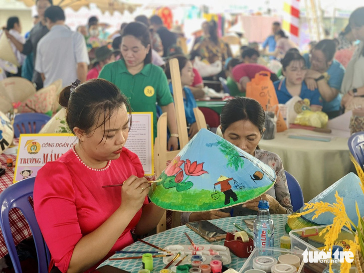 Các đội chăm chú trang trí nón lá - Ảnh: HOÀI PHƯƠNG