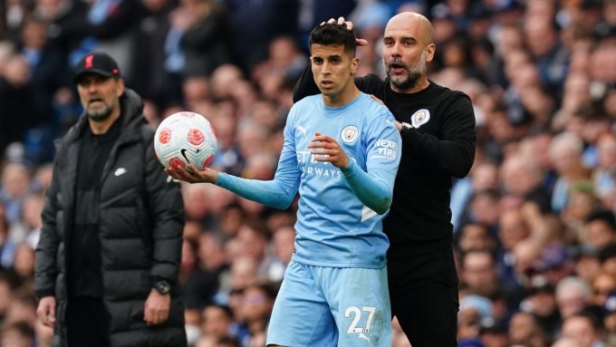 HLV Guardiola và Cancelo trong một trận Man City đấu Liverpool ở Ngoại hạng Anh. Ảnh: DPA