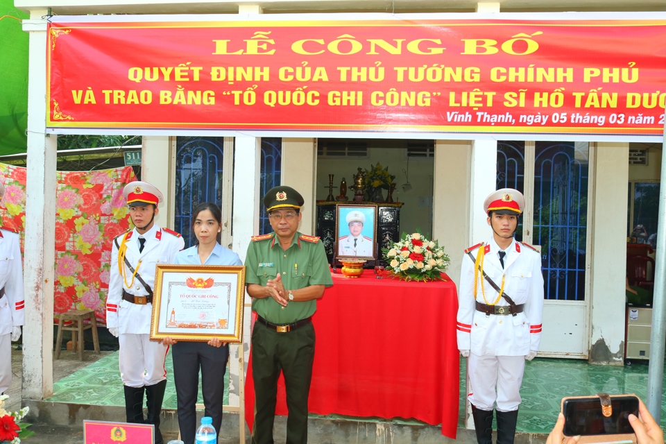 Gi&aacute;m đốc C&ocirc;ng an tỉnh Đồng Th&aacute;p Nguyễn Văn Hiểu trao bằng Tổ quốc ghi c&ocirc;ng cho gia đ&igrave;nh liệt sĩ Hồ Tấn Dương. (Ảnh PV)