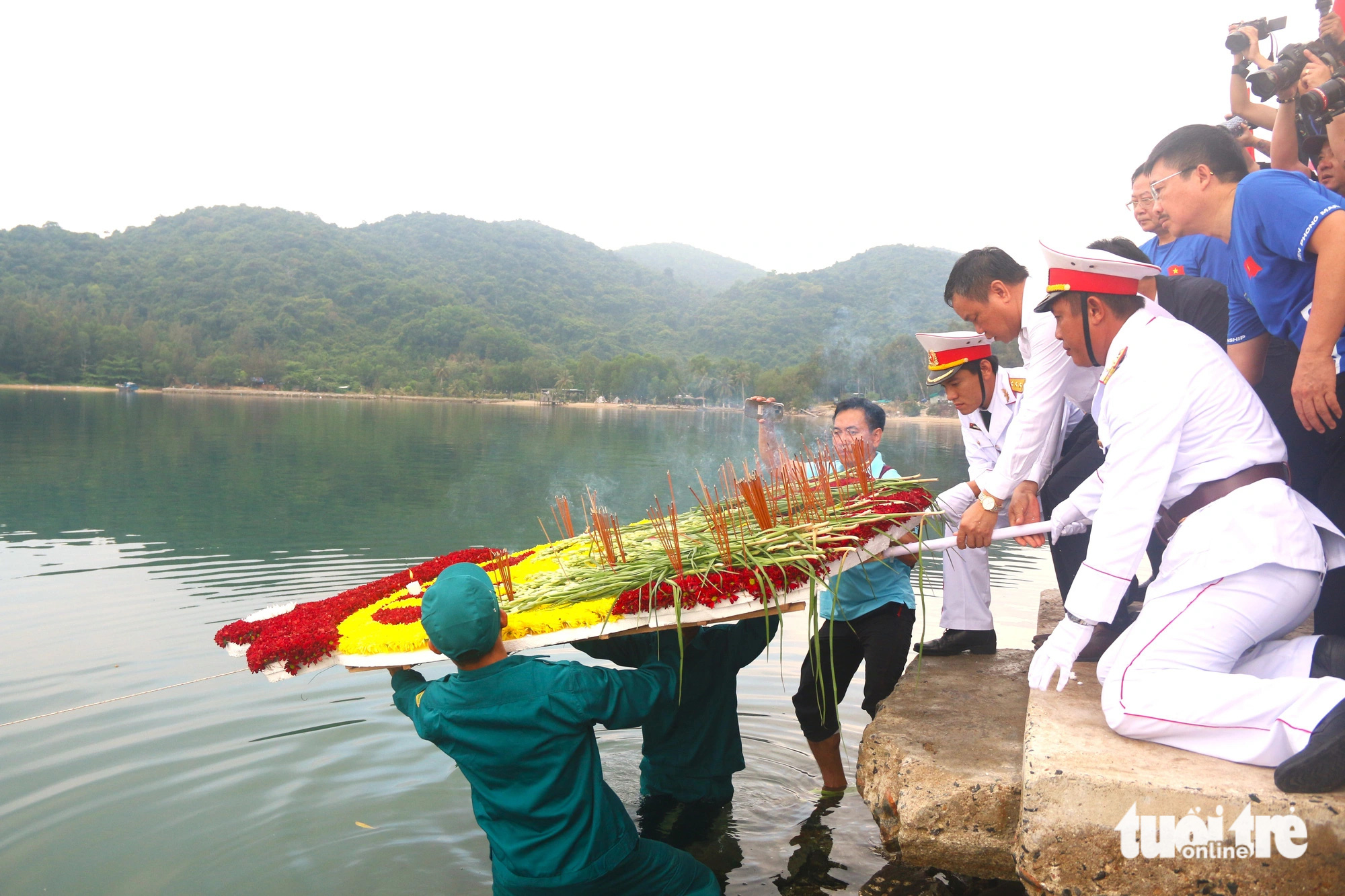 Các đại biểu thực hiện nghi thức thả hoa tưởng nhớ các chiến sĩ Tàu Không số Vũng Rô - Ảnh: NGUYỄN HOÀNG