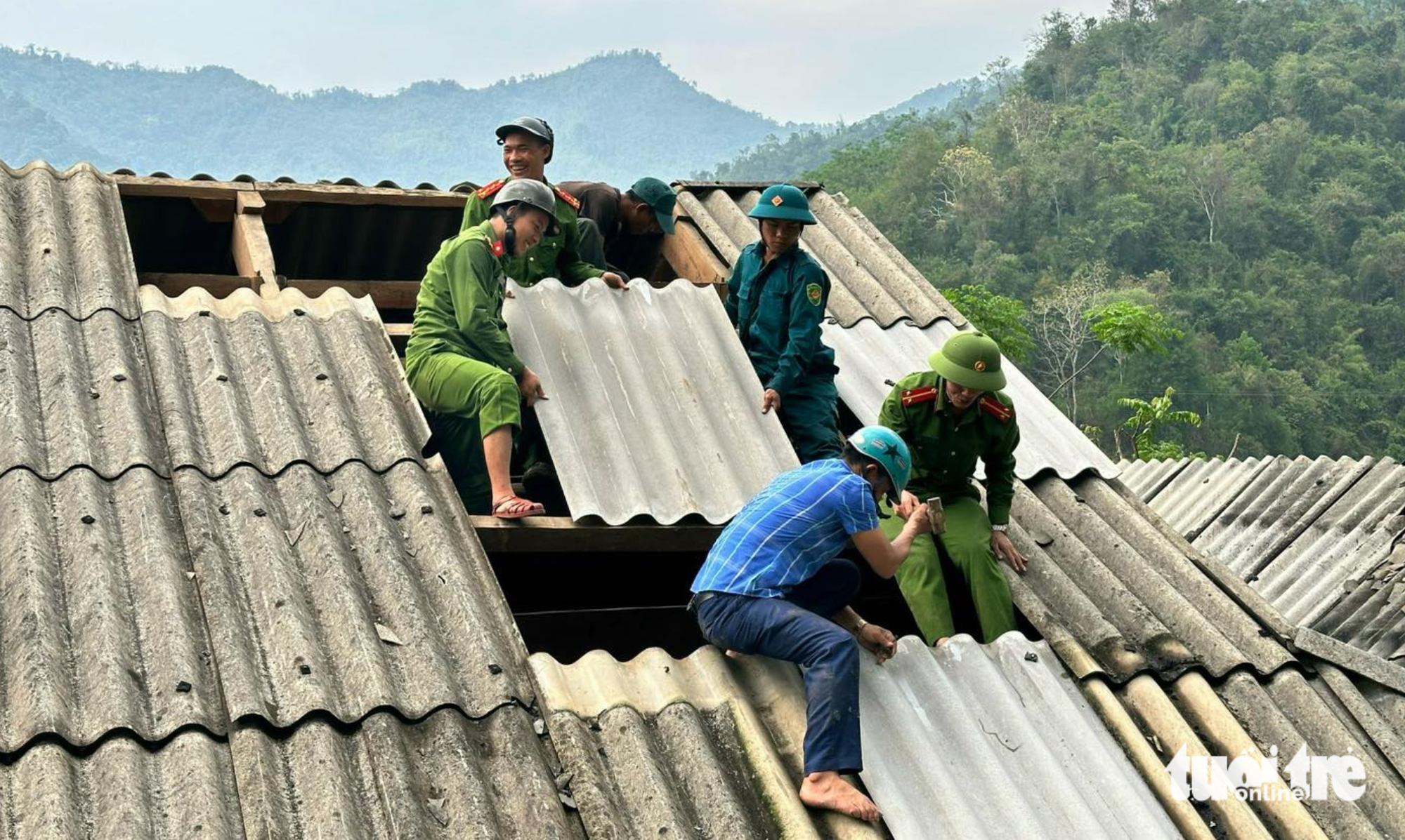 Nhiều lực lượng cùng tham gia hỗ trợ người dân lợp lại mái nhà do ảnh hưởng của mưa đá, dông lốc - Ảnh: TÂM PHẠM