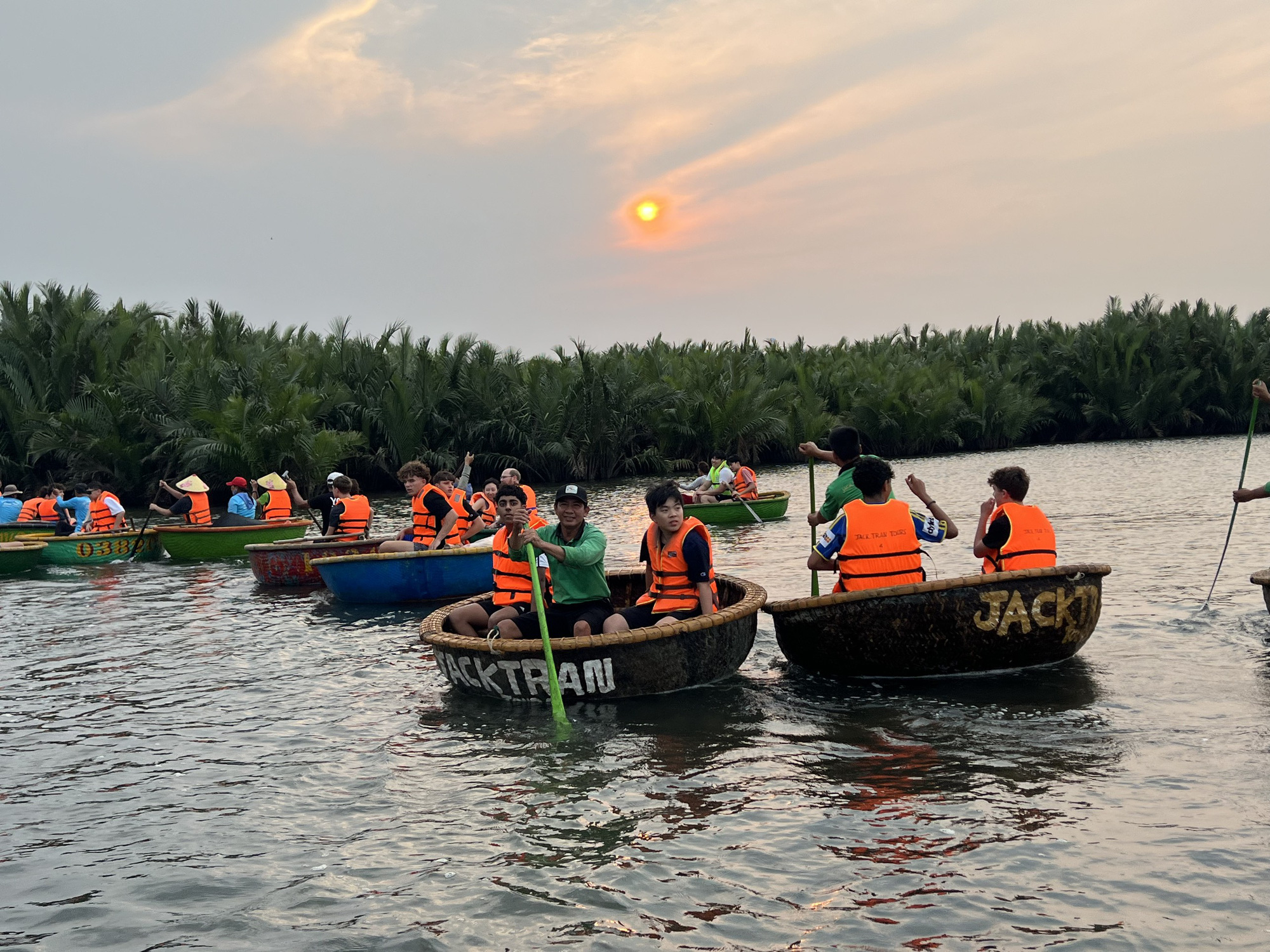 Khách nước ngoài trải nghiệm tour tham quan rừng dừa Cẩm Thanh bằng thúng chai - Ảnh: B.D.