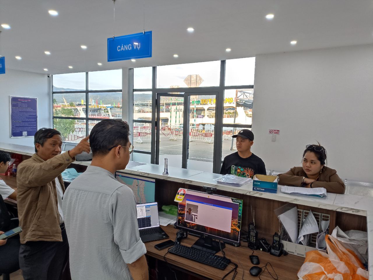 A group of people standing in front of a desk  Description automatically generated