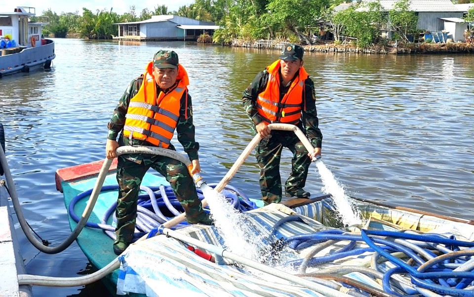 Bộ đội QK9 đang chuyển nước ngọt từ t&agrave;u chuy&ecirc;n dụng sang c&aacute;c ghe để vận chuyển nước đến c&aacute;c k&ecirc;nh rạch nhỏ hẹp cho người d&acirc;n (CTV)