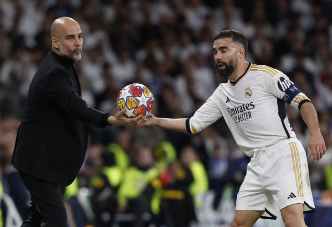 HLV Guardiola giao bóng cho hậu vệ Real Dani Carvajal trong trận tứ kết lượt đi Champions League trên sân Bernabeu ngày 9/4. Ảnh: Reuters