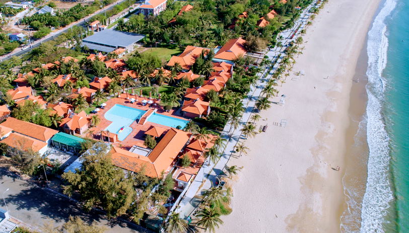 A beach with buildings and a pool  Description automatically generated