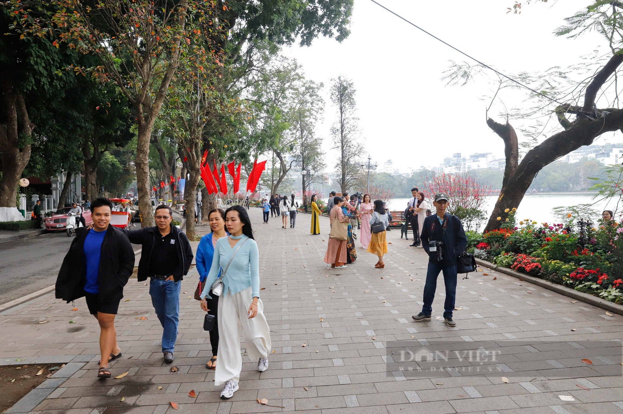 Sắc đào bung nở bên thảm hoa tuyệt đẹp quanh Hồ Gươm - Ảnh 1.