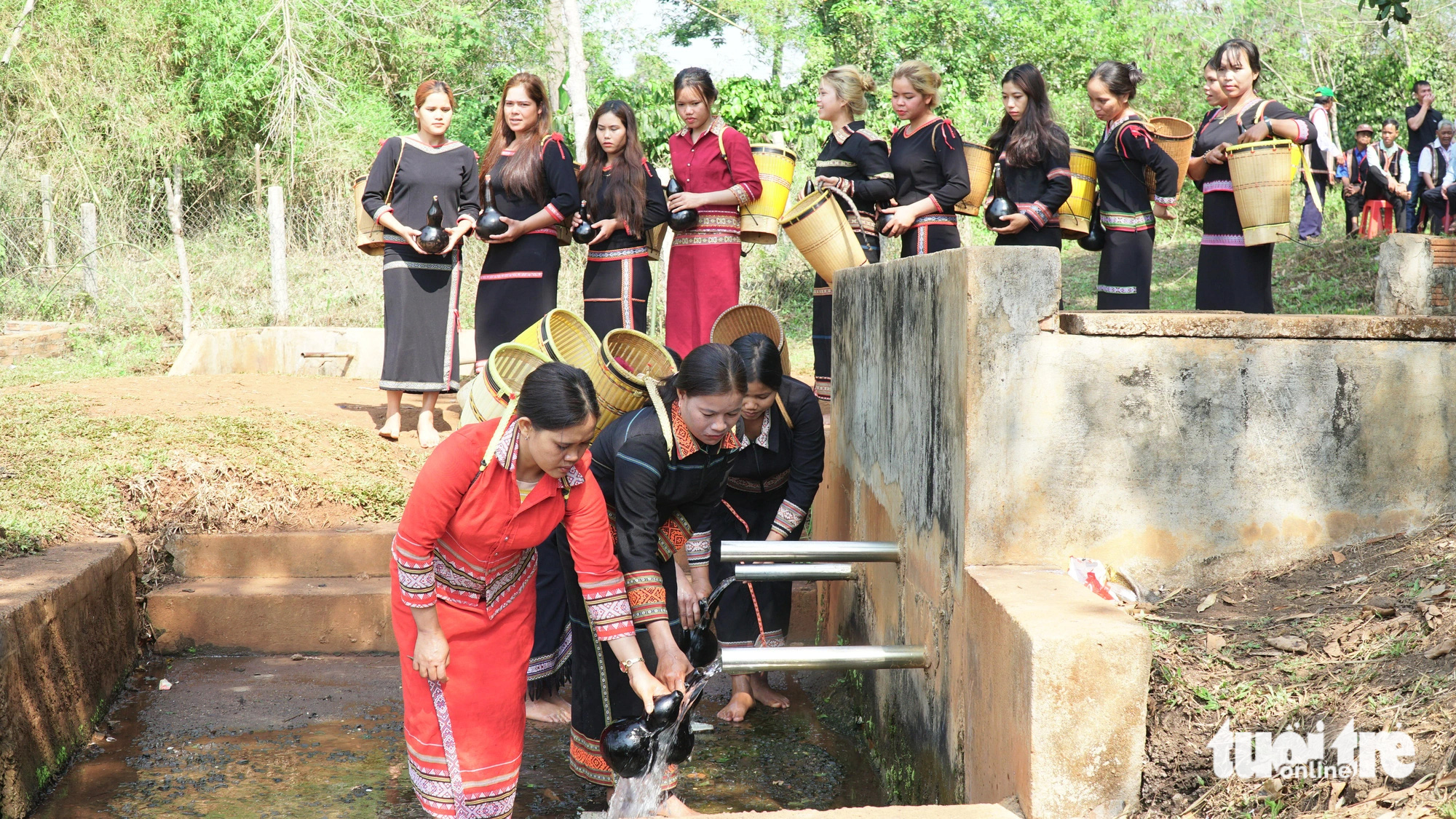 Nghi thức lấy nước vào bầu khô với mong muốn nguồn nước luôn dồi dào, tuôn chảy - Ảnh: BỒNG SƠN 