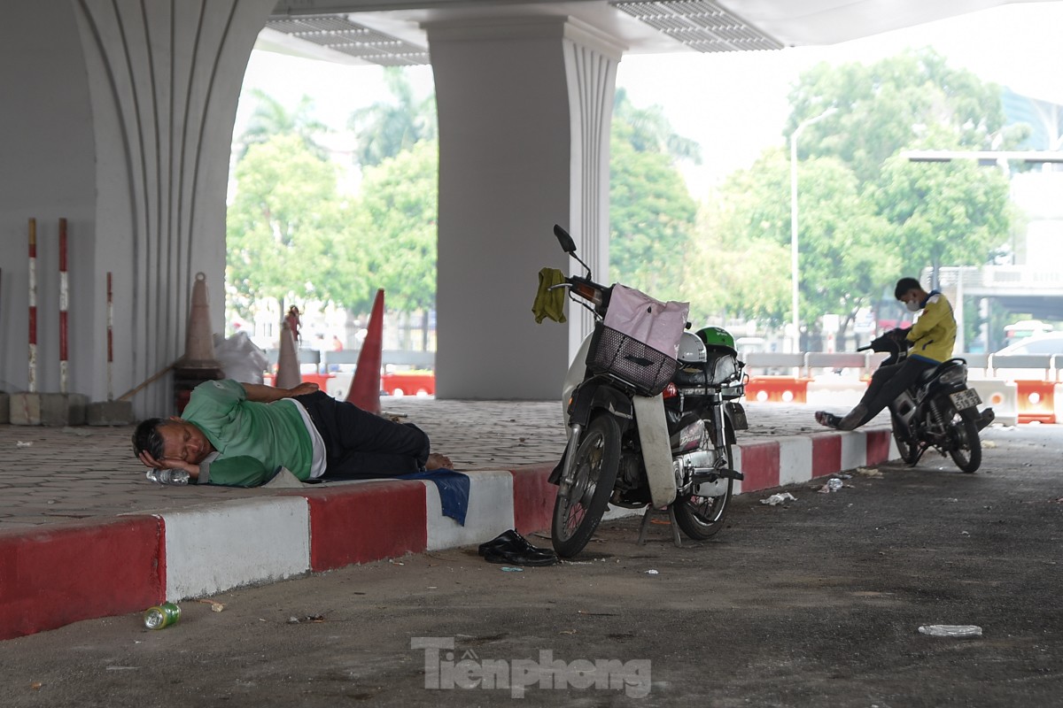 Giữa trưa, người lao động nằm vạ vật dưới gầm cầu để tránh cái nắng như nung ảnh 12