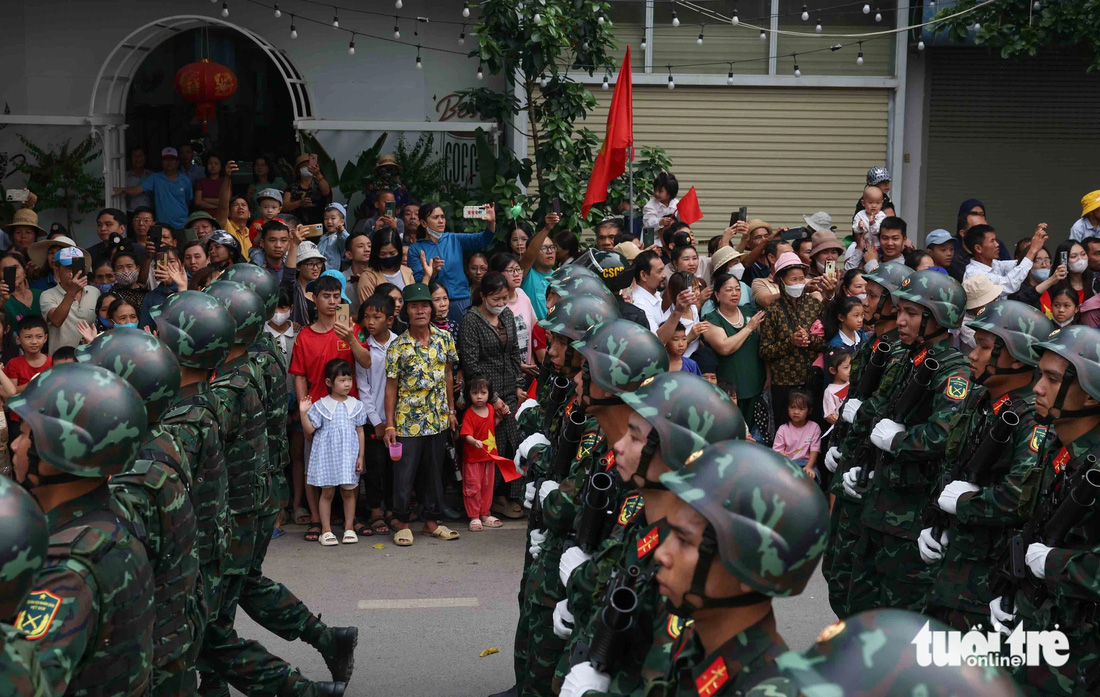 Người dân đứng chật kín hai bên đường, từ người già đến trẻ nhỏ ngắm nhìn những người lính diễu binh - Ảnh NGUYỄN KHÁNH