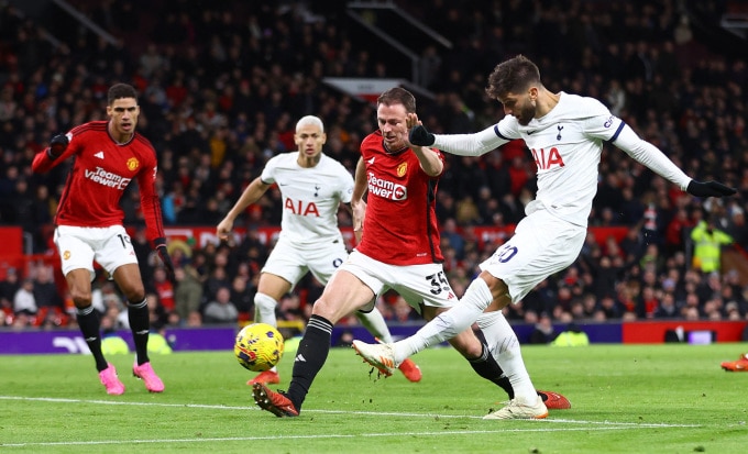 Hậu vệ Jonny Evans không ngăn được cú sút ghi bàn của tiền vệ Tottenham Rodrigo Bentancur trong trận hòa 2-2 ở vòng 21 Ngoại hạng Anh trên sân Old Trafford ngày 14/1/2024. Ảnh: Reuters