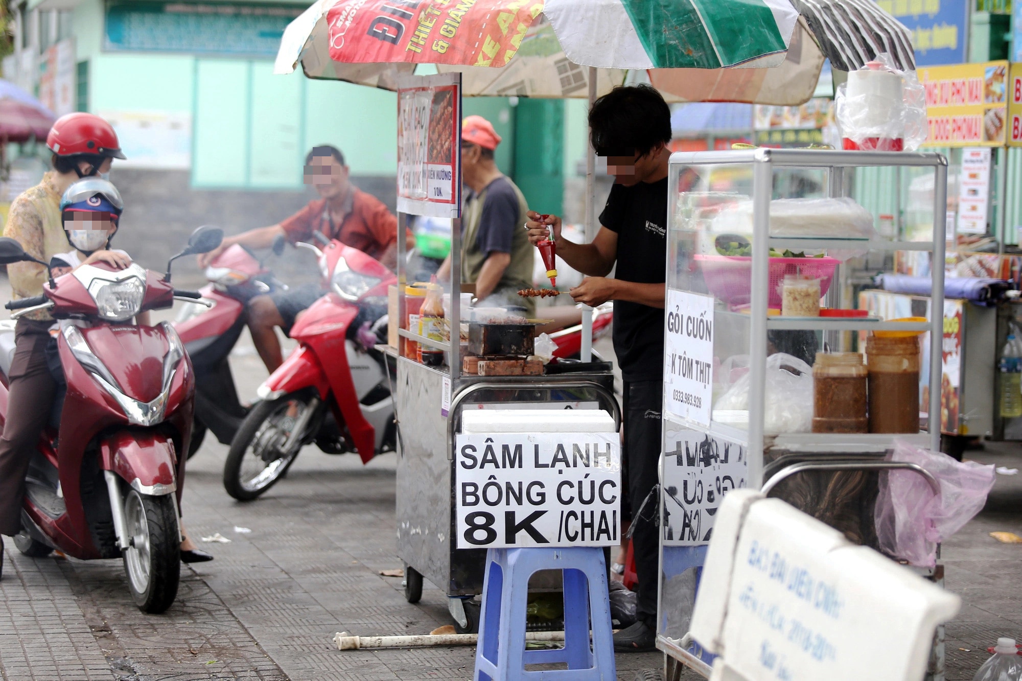 Tại cổng trường các cấp học ở TP.HCM không khó để thấy các xe bán hàng rong, quà vặt cho học sinh - Ảnh: PHƯƠNG QUYÊN