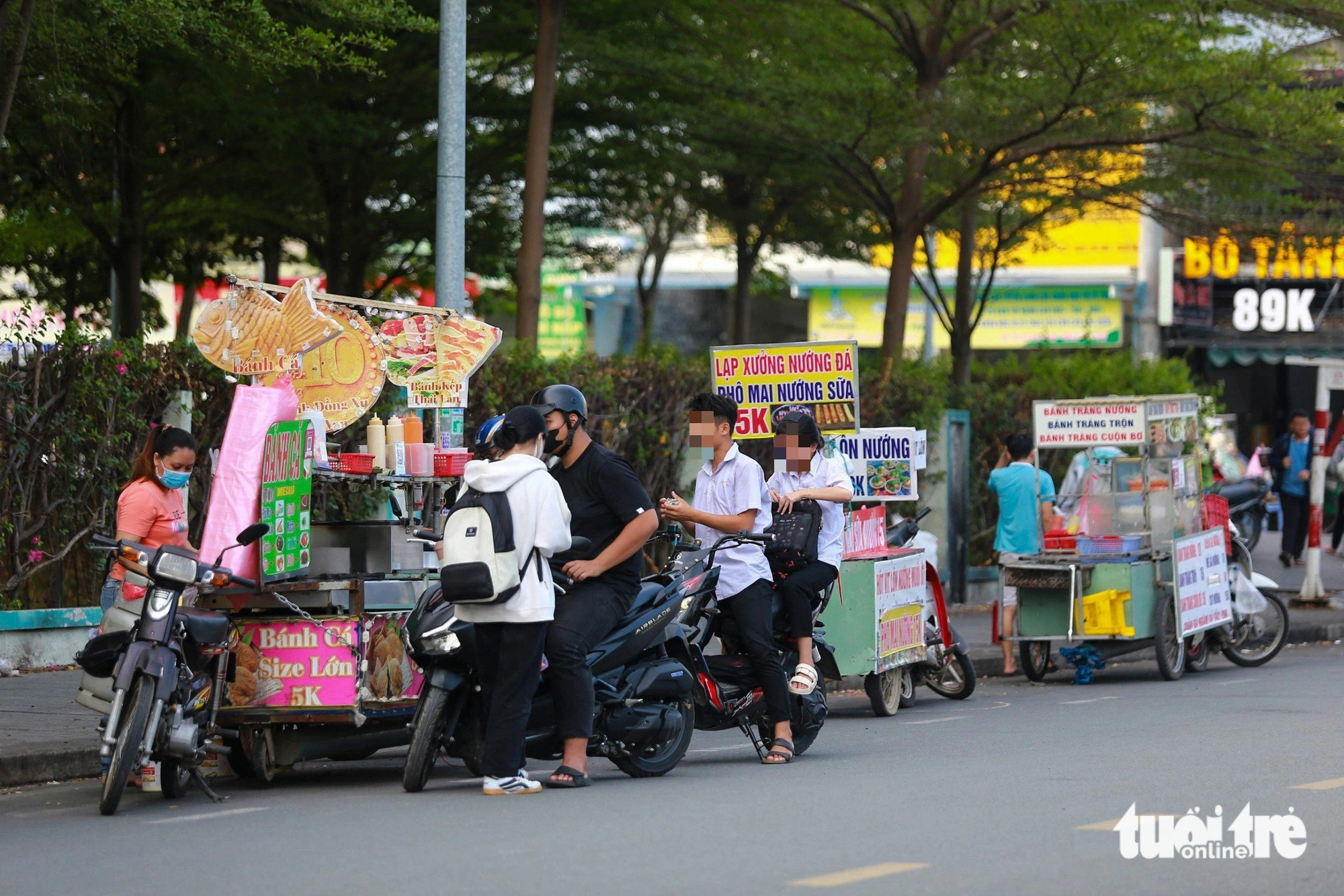 Hàng rong với đủ các loại thức ăn, nước uống... xếp hàng dài trước cổng KTX khu B (khu đô thị Đại học Quốc gia TP.HCM) chiều 9-5