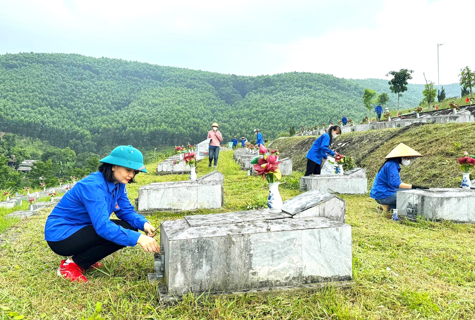 Đoàn viên thanh niên tham gia dọn dẹp, chỉnh trang tại khuôn viên Nghĩa trang liệt sĩ Nầm - Ảnh: H.A.