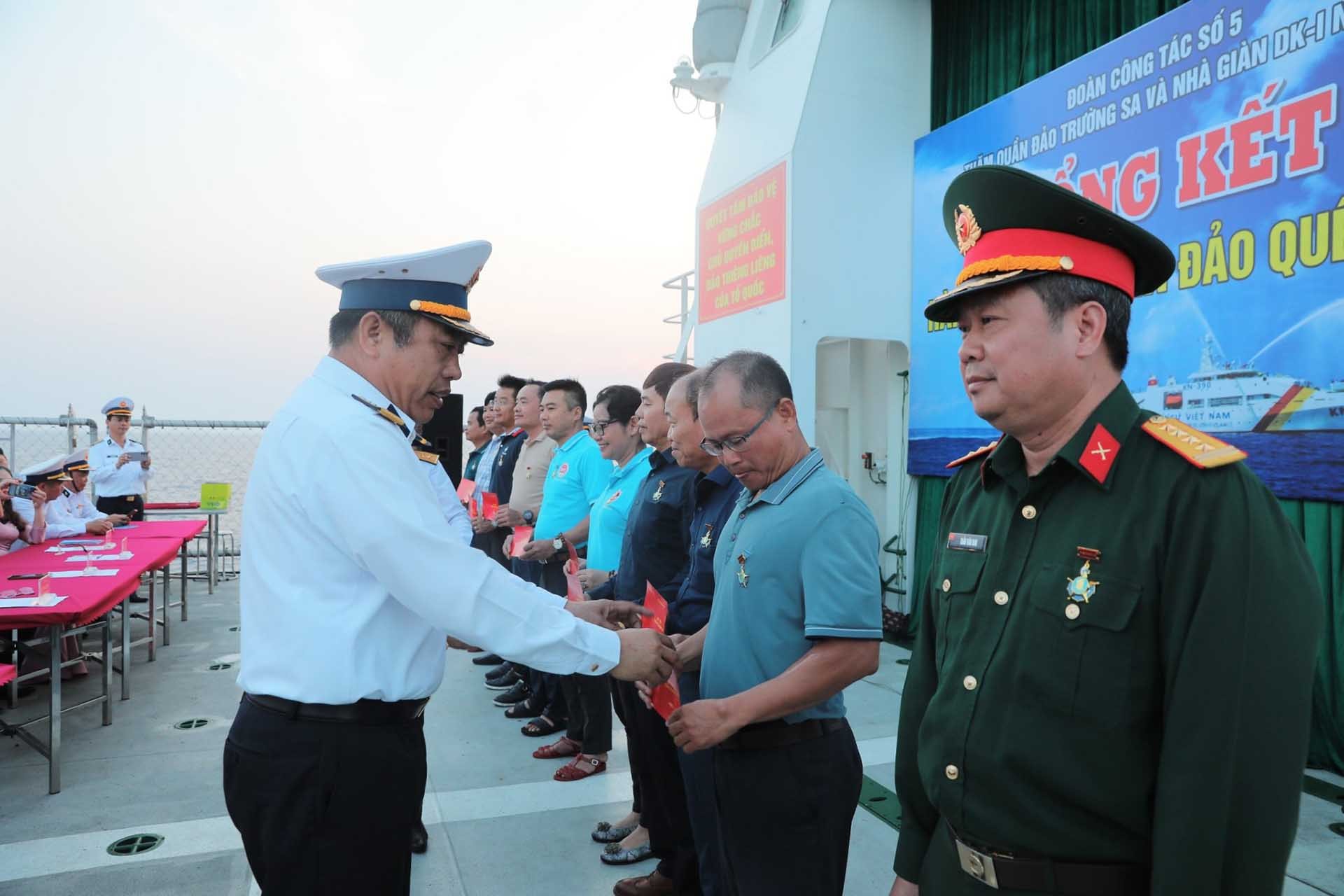 Đại tá Đoàn Bảo Anh trao huy hiệu chiến sĩ Trường Sa cho các đại biểu tham gia chuyến công tác tại Trường Sa, ngày 8/4. (Ảnh: Nguyến Tấn Tuấn)