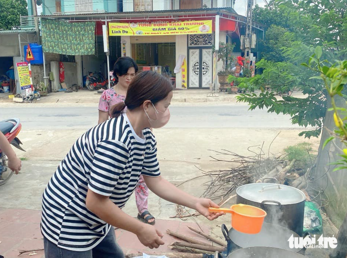 Các cô giáo hì hụi chuẩn bị củi, nhóm bếp để nấu chè đậu đỏ - Ảnh: TÂM PHẠM