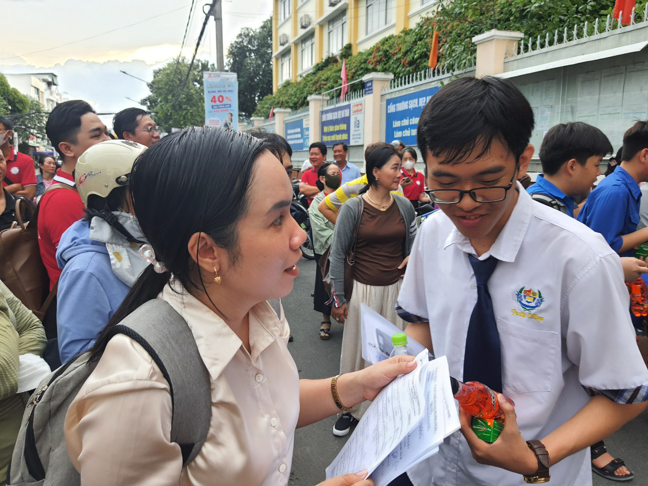 Giáo viên đón học sinh tại cổng điểm thi Trường Đoàn Thị Điểm (quận Ninh Kiều, TP Cần Thơ) để hỏi thăm tình hình làm bài thi môn toán. Đa số thí sinh tại đây nói đề vừa phải, các em có thể làm được 7, 8 điểm - Ảnh: T. LŨY